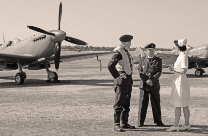 RAF pilot, chaplain and nurse in front of Spitfires, Flying Legends Duxford